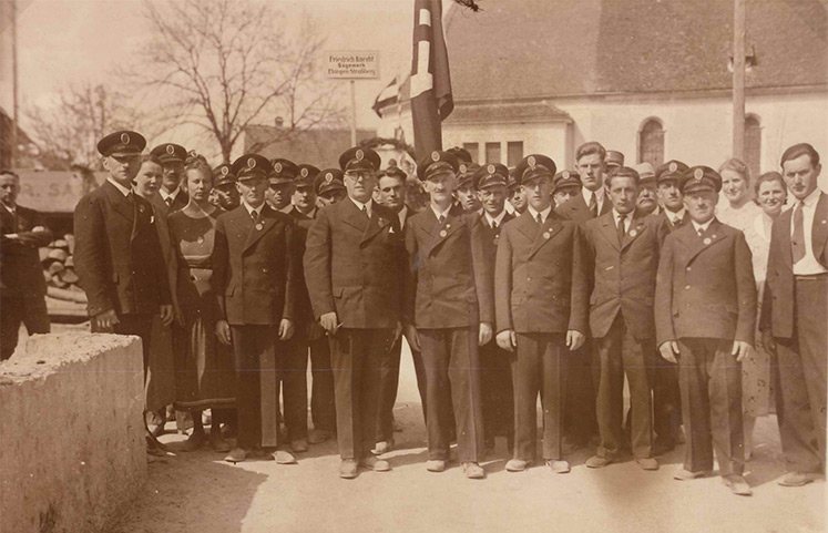 Historische Gruppenaufnahme von herren in Uniformen vor der Kirche Sankt Verena in Straßberg