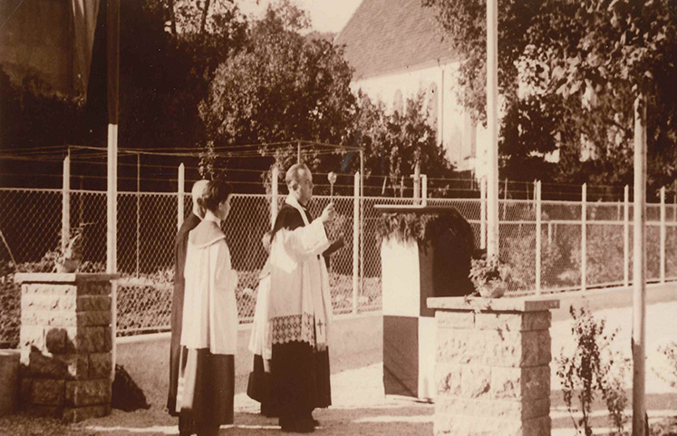 Historische Aufnahme eines Pfarrers mit Ministrant bei einem Gottesdienst im Freien