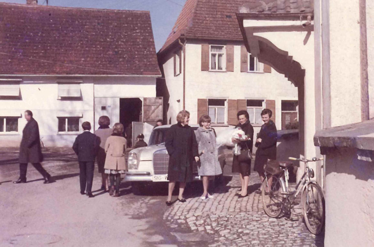 Frauen mit einem Baby auf dem Arm vor der Kirche Sankt Verena bei der Taufe