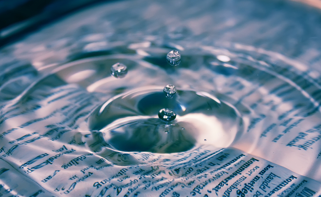 Wassertropfen die auf ein Gebetsbuch tropfen