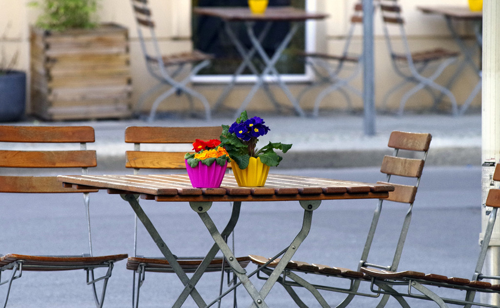 Eine Holzsitzgruppe mit Blumen auf dem Tisch