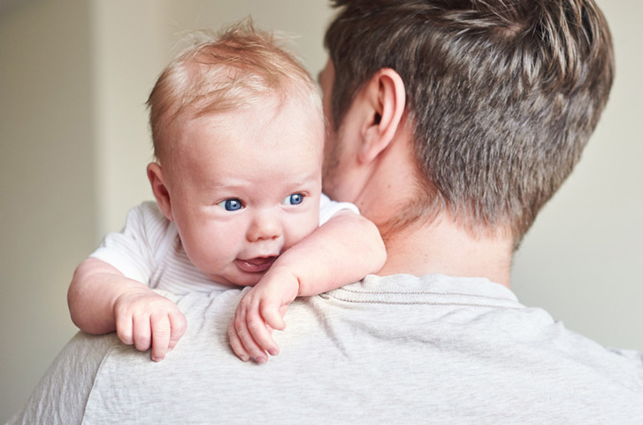 Ein Baby das über die Schulter blickt